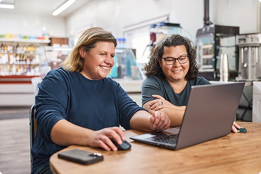 Laurie and Candace working on a laptop